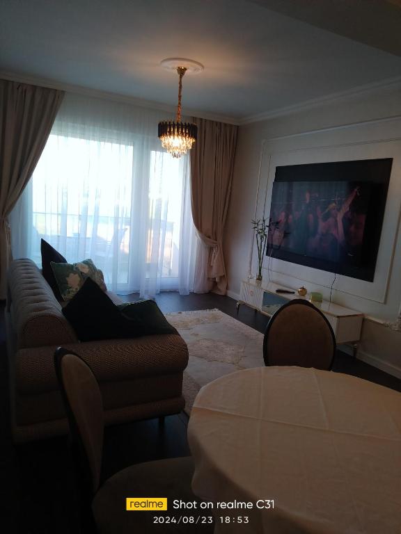 a living room with a couch and a flat screen tv at Avangarde de Lux Apartment in Seleuş