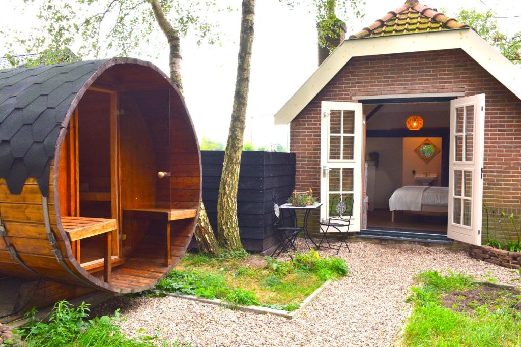 una piccola casa hobbit con un letto e una camera da letto di Bed & Breakfast Puur Natuur Putten, met privé sauna a Putten