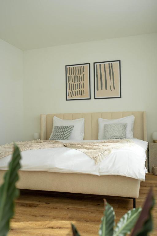 a bedroom with a bed with two pictures on the wall at NH 6 Interlaken-Luzern I Lake I Mountain I connect in Sachseln
