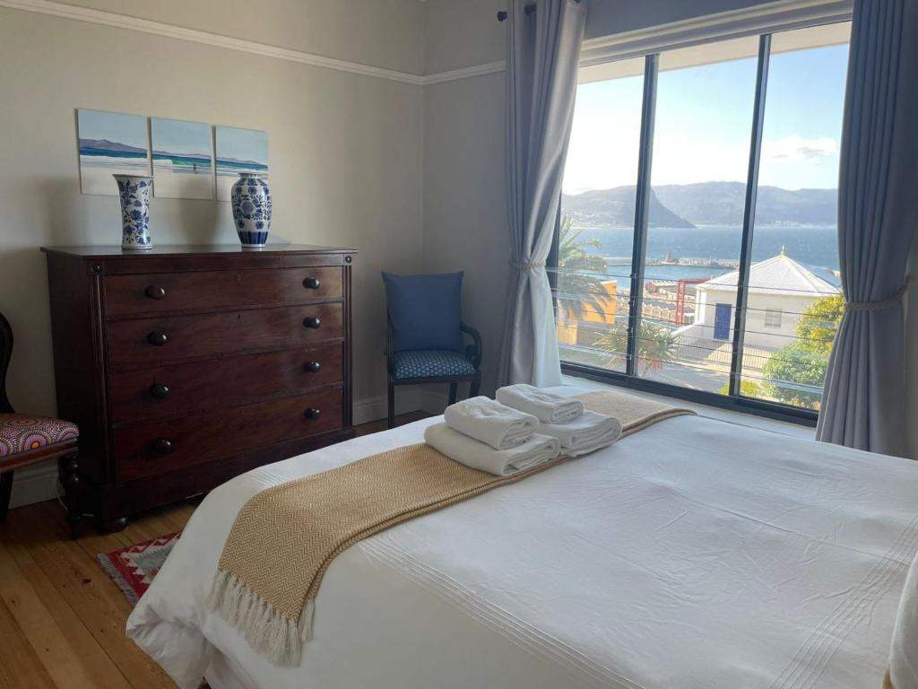 a bedroom with a bed with two towels on it at Little Penguin in Simonʼs Town