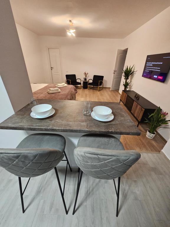 a table with two chairs and plates on top of it at Terrace Green Hill House in Braşov