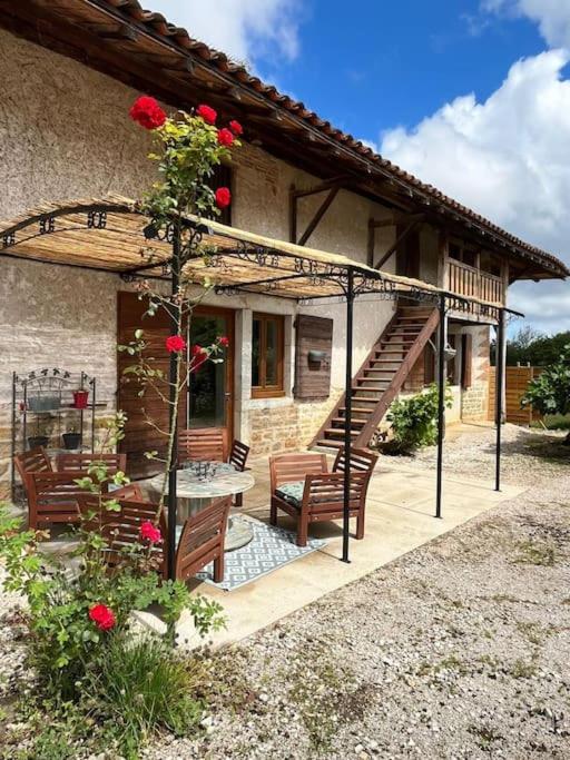 une maison avec une terrasse dotée de 2 chaises et d'un escalier dans l'établissement Gîte Les Petits Belézins, à Saint-Amour