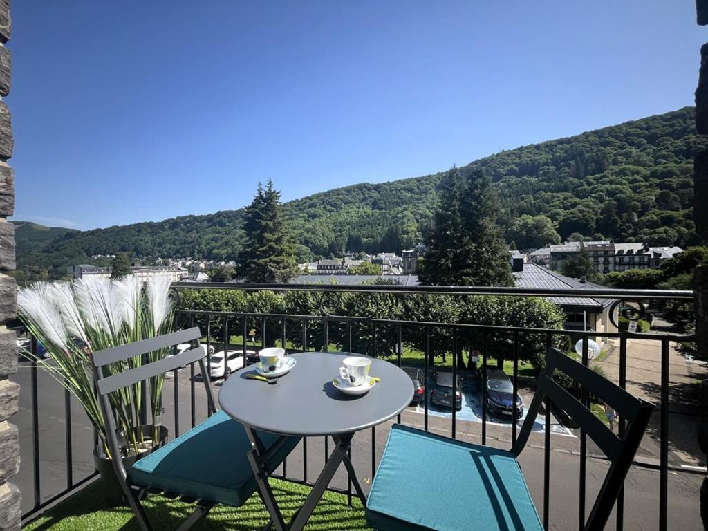 une table et des chaises sur un balcon avec vue dans l'établissement Charmant T2 BIS proche des Thermes, balcon, 6 pers, Mont-Dore - FR-1-608-12, à Le Mont-Dore