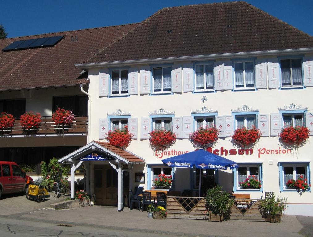 a large white building with flowers on the windows at Pension Ochsen, Ferienwohnungen in Löffingen