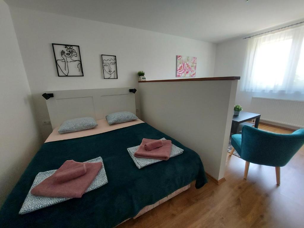 a bedroom with a bed and a blue chair at Garden House Novi Sad in Novi Sad
