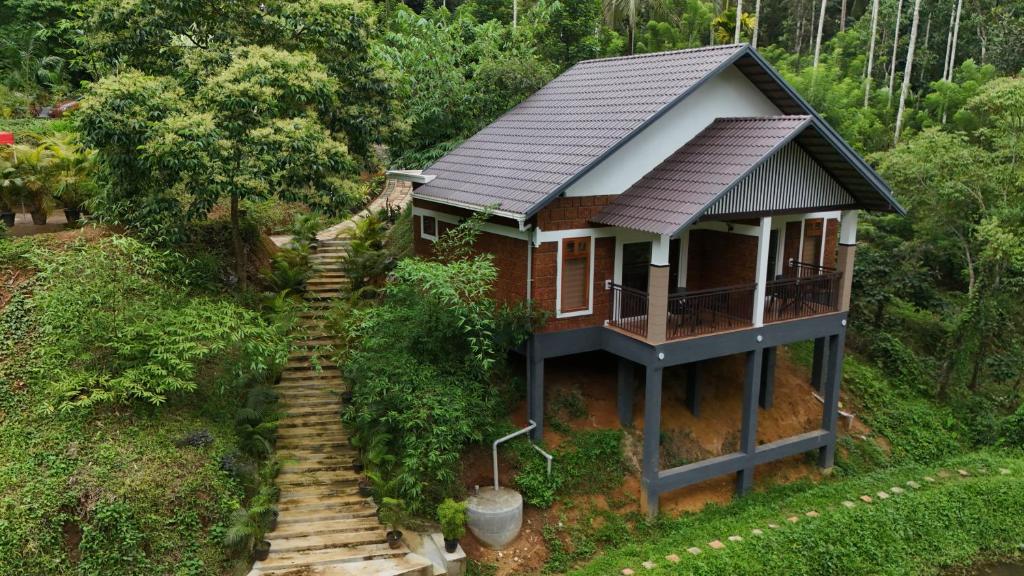 a house on a hill with stairs leading up to it at Casta Wild Resort in Batheri