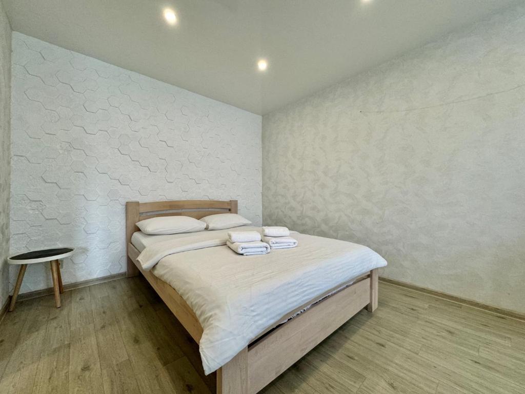 a bedroom with a bed with two towels on it at ApartPoltava Світлі та затишні апартаменти в Скандинавському стилі ЦЕНТР БАНКІВСЬКИЙ ЧЕК in Poltava