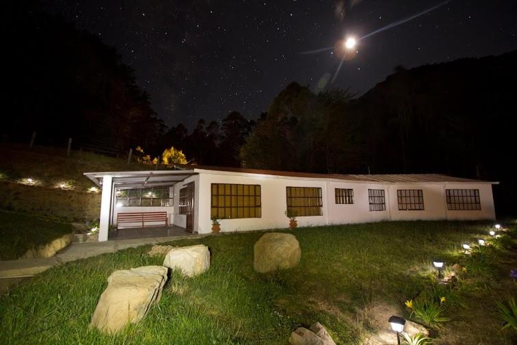 a white building in a yard at night at Pinares del Carrizalito in El Cocuy