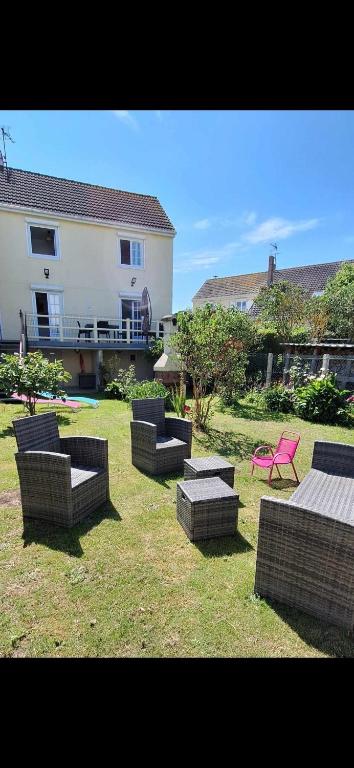 un groupe de chaises et de tables dans une cour dans l'établissement Villa Berckarosse, à Berck-sur-Mer