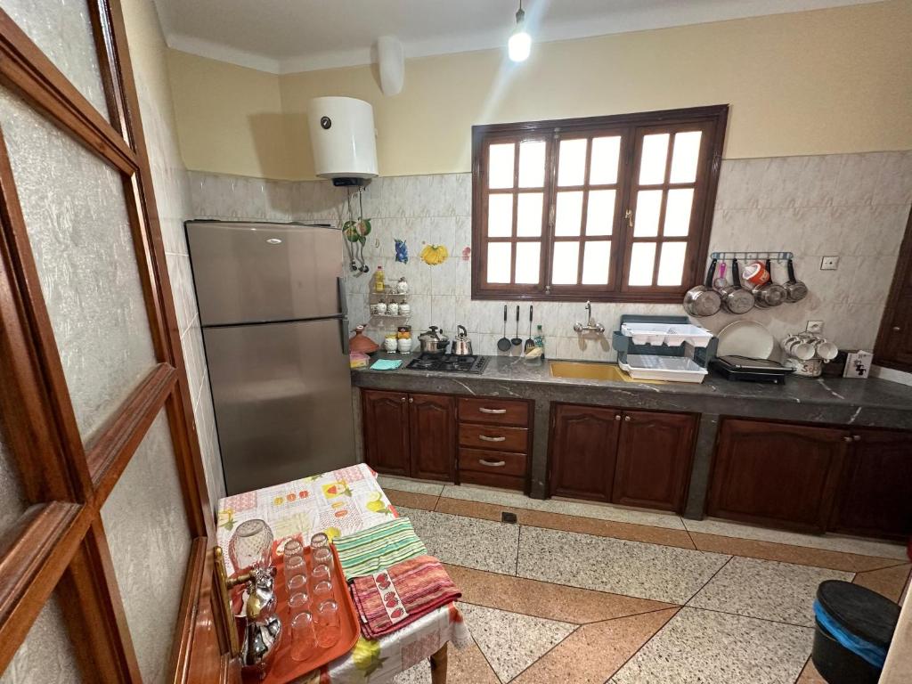 a kitchen with a stainless steel refrigerator and a window at Chez-soi in Meknès
