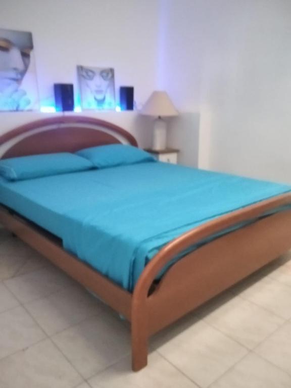 a bed with a wooden frame in a bedroom at "HOUSE OF LELLA 2" appartamento 1 camera da letto - M1 METRO ROSSA in Milan