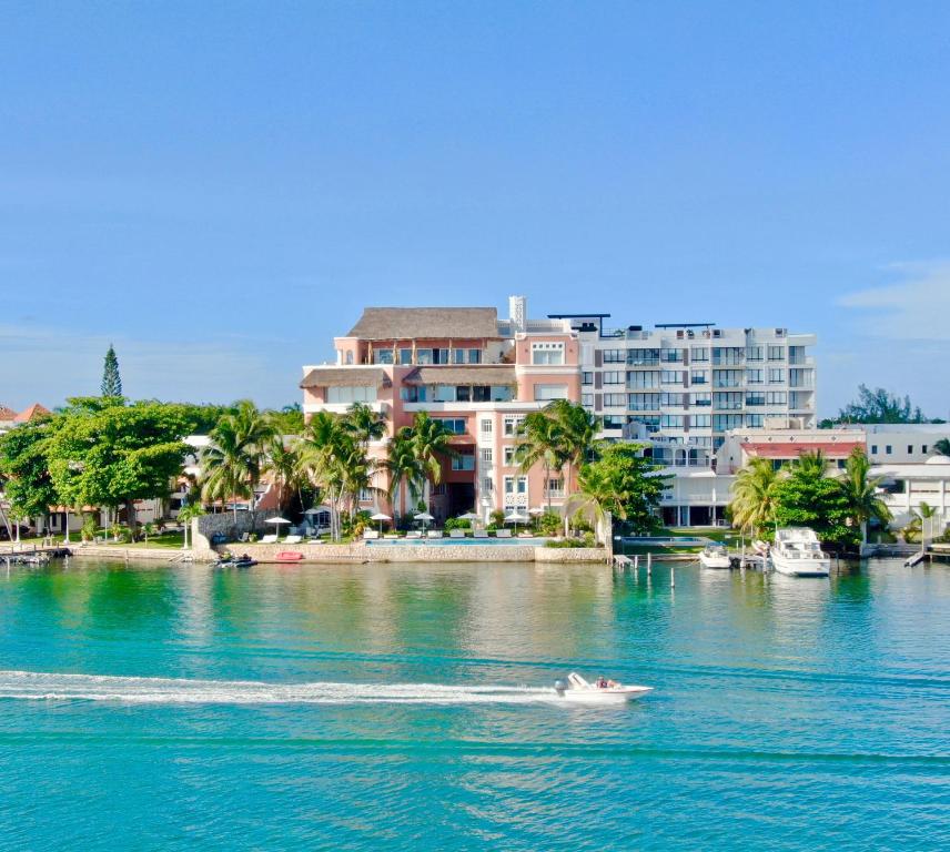 a boat on the water in front of buildings at Casa Tortugas Boutique Hotel - A Hidden Gem in Cancun in Cancún
