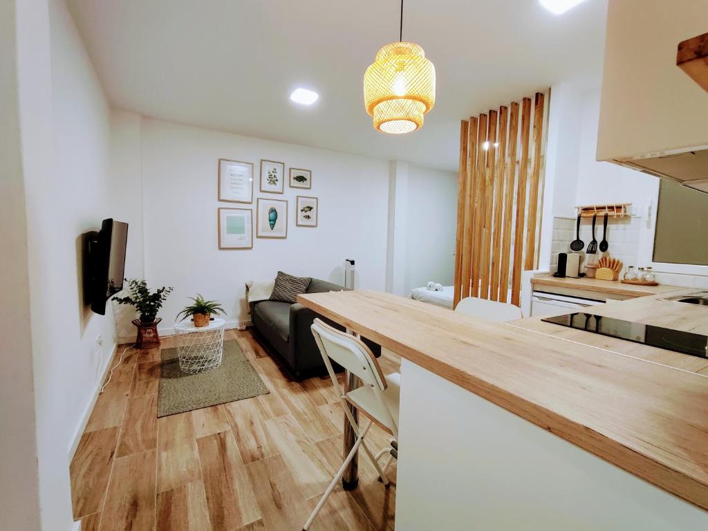 a kitchen and living room with a table and a couch at LM27 Beach "Little Blondies" in Las Palmas de Gran Canaria