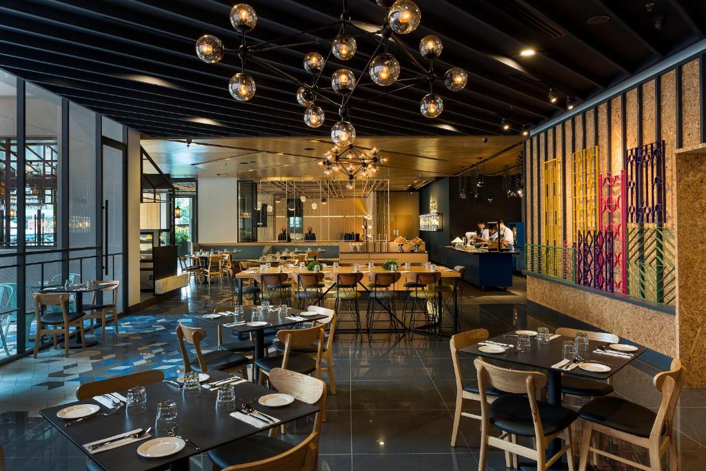 a restaurant with tables and chairs and a bar at The Kuala Lumpur Journal Hotel in Kuala Lumpur