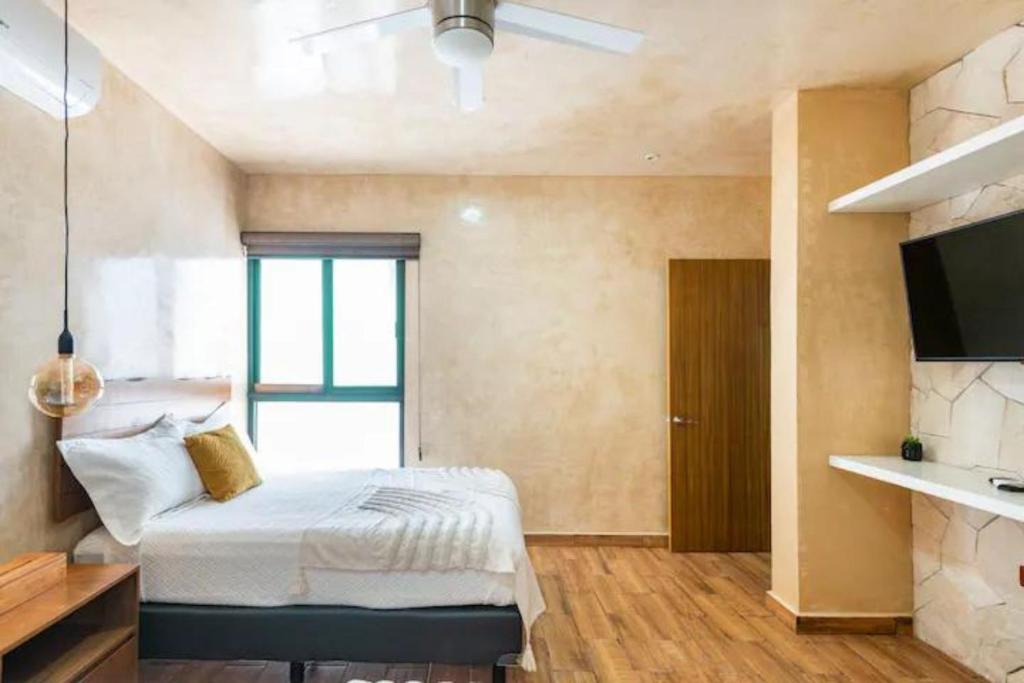 a bedroom with a bed and a television in it at New apartment with all services and pool Marcos #1 in Isla Mujeres