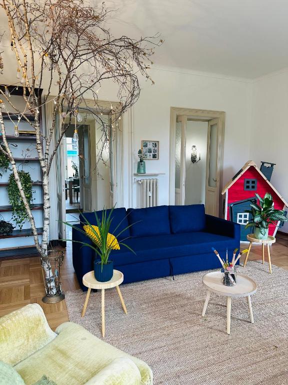 a living room with a blue couch and two tables at Liberty House in Turin