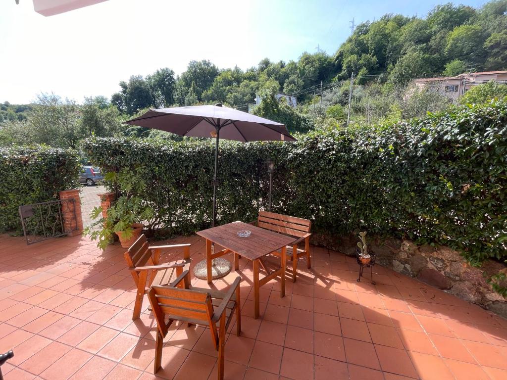 stół i krzesła z parasolem na patio w obiekcie Appartamento comodo per Lerici e 5 Terre w mieście Piano di Follo