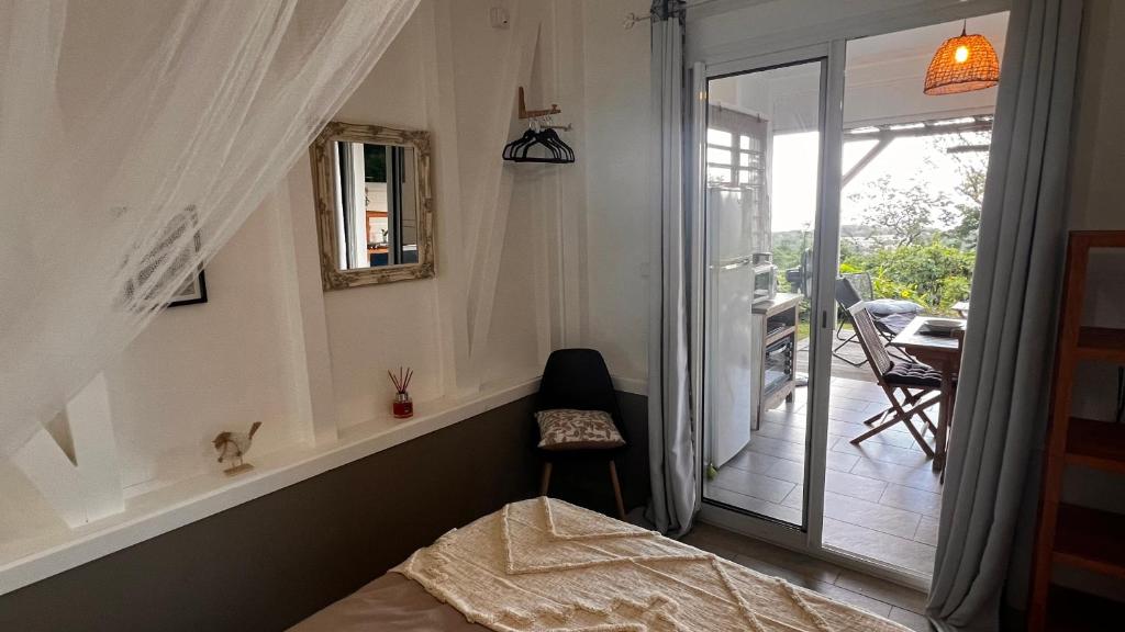 una camera con letto e porta scorrevole in vetro di PAVILLON TI GEMME LE DIAMANT a Le Diamant
