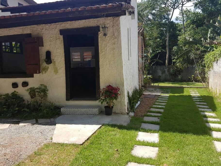 a house with a door and a grass yard at Loft situado a 700 metros da praia de Boiçucanga in Boicucanga