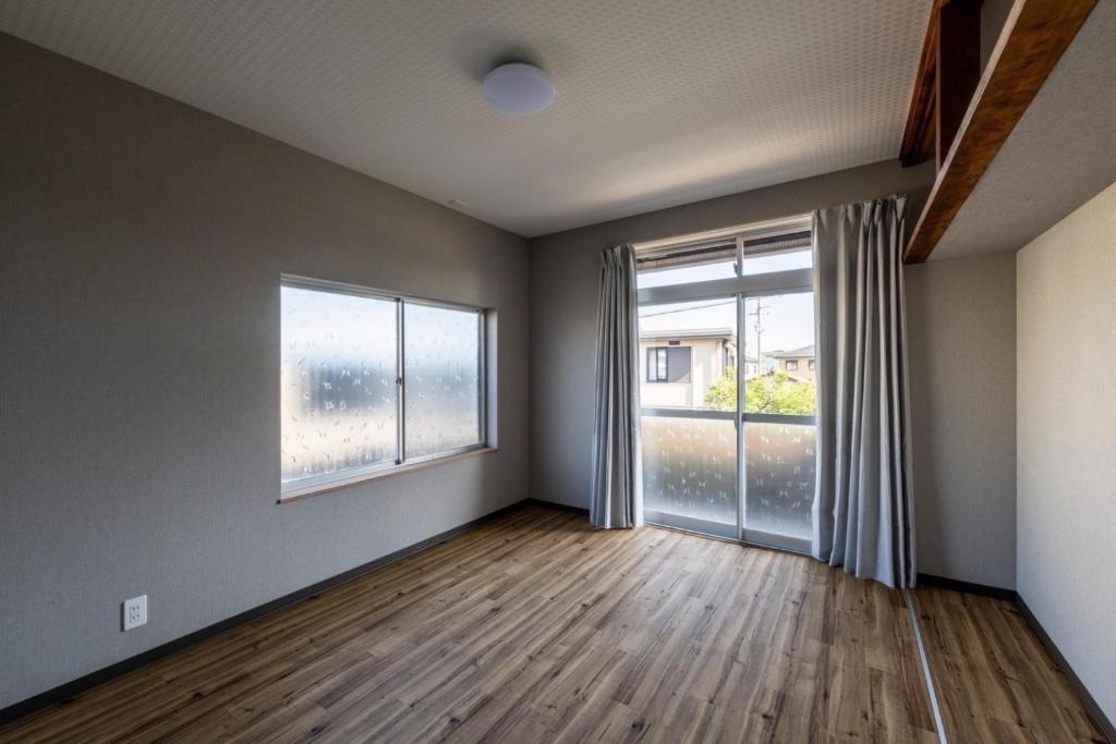 an empty room with a large window and wooden floors at Oyado Yadokari - Vacation STAY 92325v in Anan