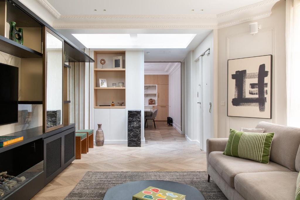 un salon avec un canapé et une télévision dans l'établissement HIGHSTAY - Luxury Serviced Apartments - Tuileries Garden, à Paris