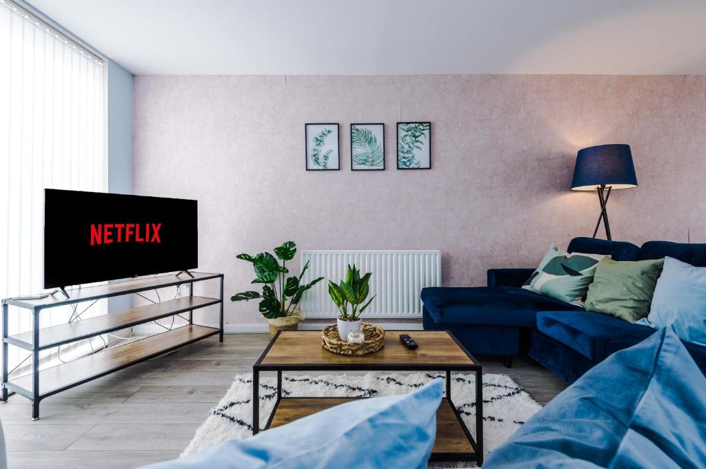 a living room with a blue couch and a tv at Luxury City Stay Coop Live & Etihad with Free Parking in Manchester