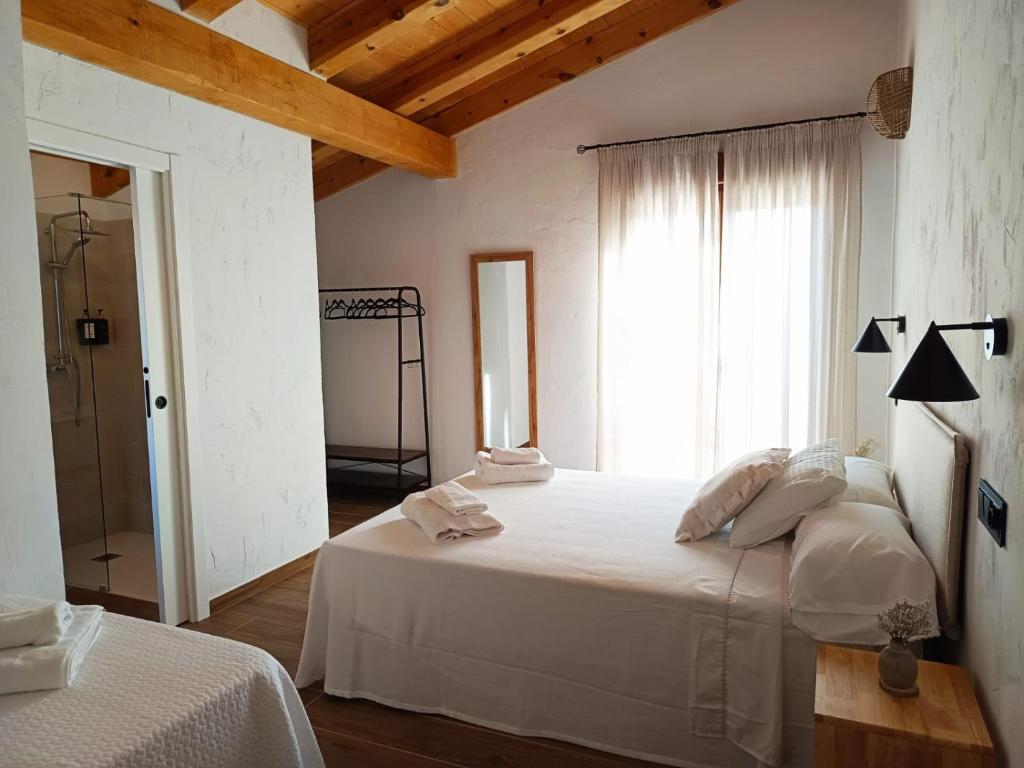 a bedroom with a white bed and a window at Casa Rural En Los Trigales in Navas de Oro