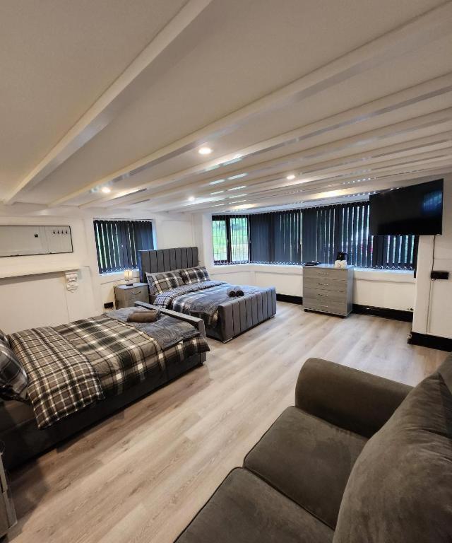 a large living room with two beds and a couch at Rainsough Cottage Guest House - Sleeps upto 8 with ensuite - Free Parking & WiFi in Manchester