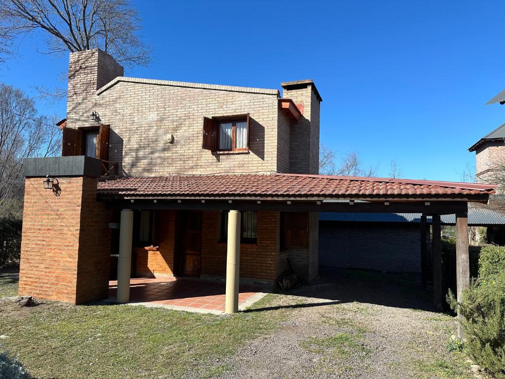 ein großes Backsteinhaus mit großem Dach in der Unterkunft Encantos del Valle - Santa Rosa de Calamuchita in Santa Rosa de Calamuchita