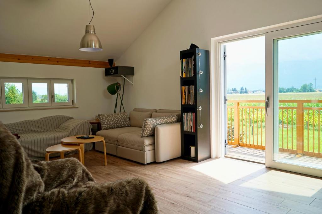 a living room with a couch and a book shelf at Ferienhaus Am Weitfeld - Ruheoase mit Garten & Bergblick nahe Salzburg in Ainring