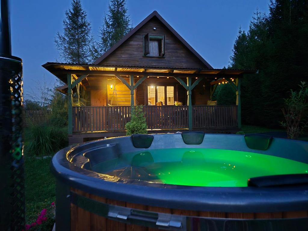 a hot tub in front of a house at Letniczówka Guciów-Pokochaj Roztocze in Guciów