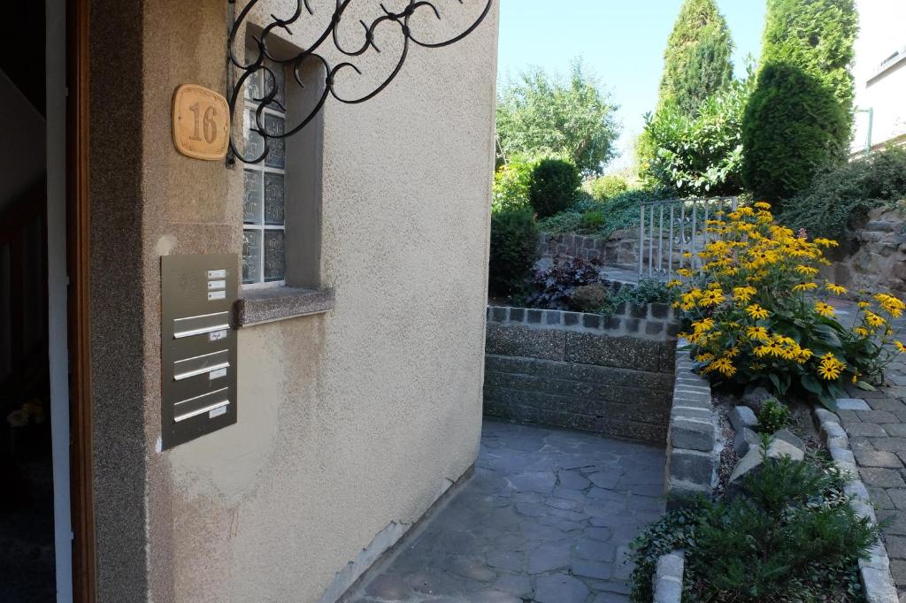 a sign on the side of a building with flowers at Ferienwohnung Jehn in Fulda