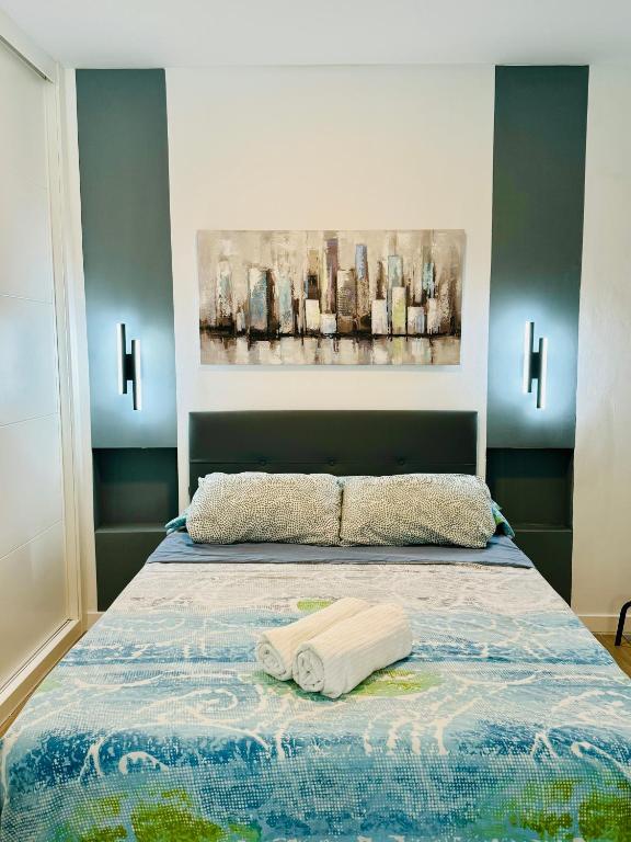 una camera da letto con un letto e un dipinto sul muro di Apartamento con Jacuzzi Privado Aguacate a Madrid