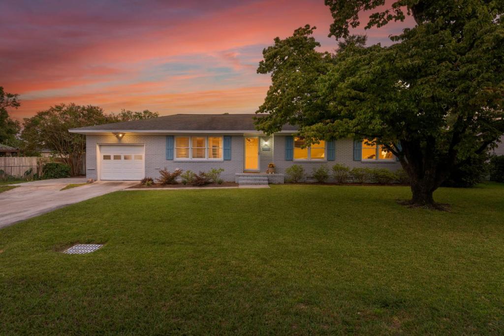 a blue house with a tree in the yard at Peace of Happiness Coastal Cottage 7 mi from Wrightsville Beach, NC in Windemere