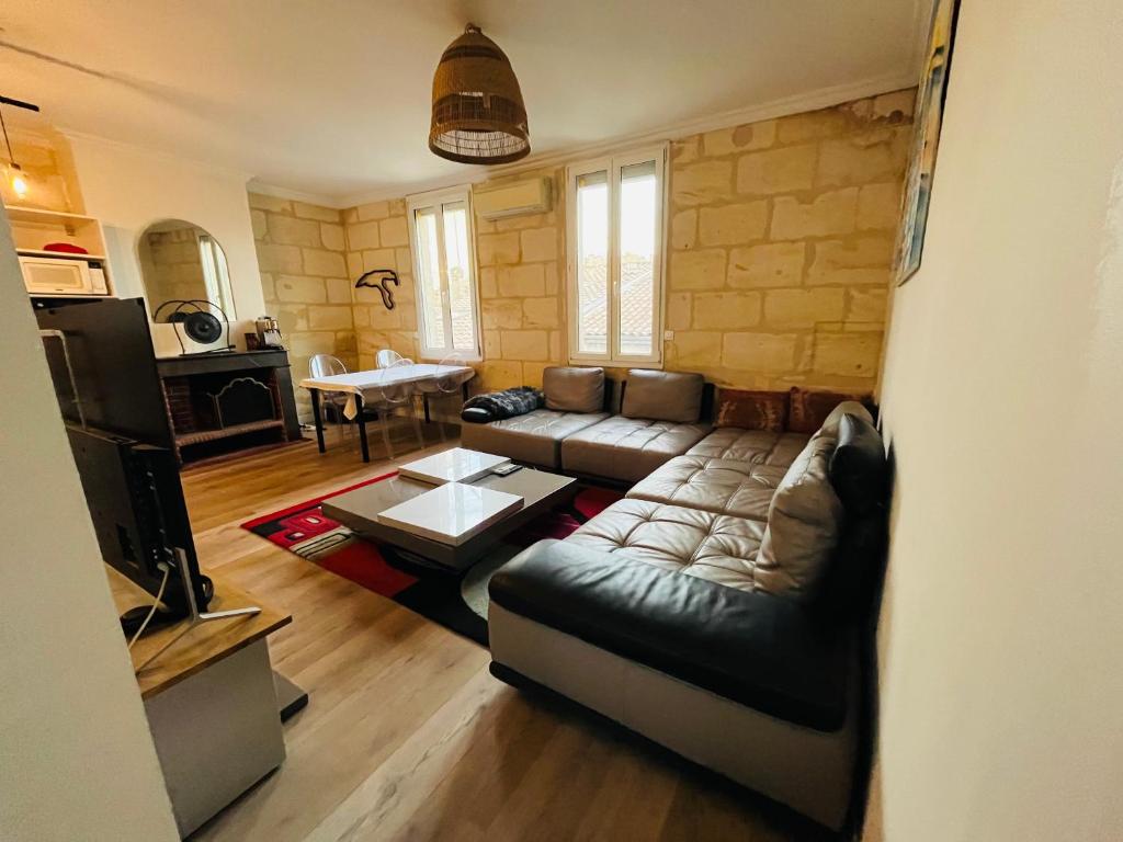 un salon avec un canapé et une table dans l'établissement Appartement Duplex - 2 Chambres - Cosy & Spacieux-, à Bordeaux