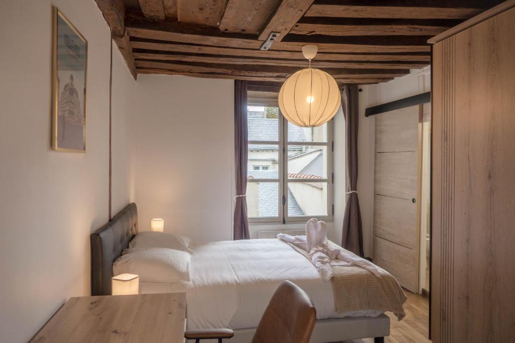 une chambre avec un lit, une table et une fenêtre dans l'établissement ORLEANS CENTRE HISTORIQUE - Charmant T2 - L'EVASION ORLEANAISE, à Orléans