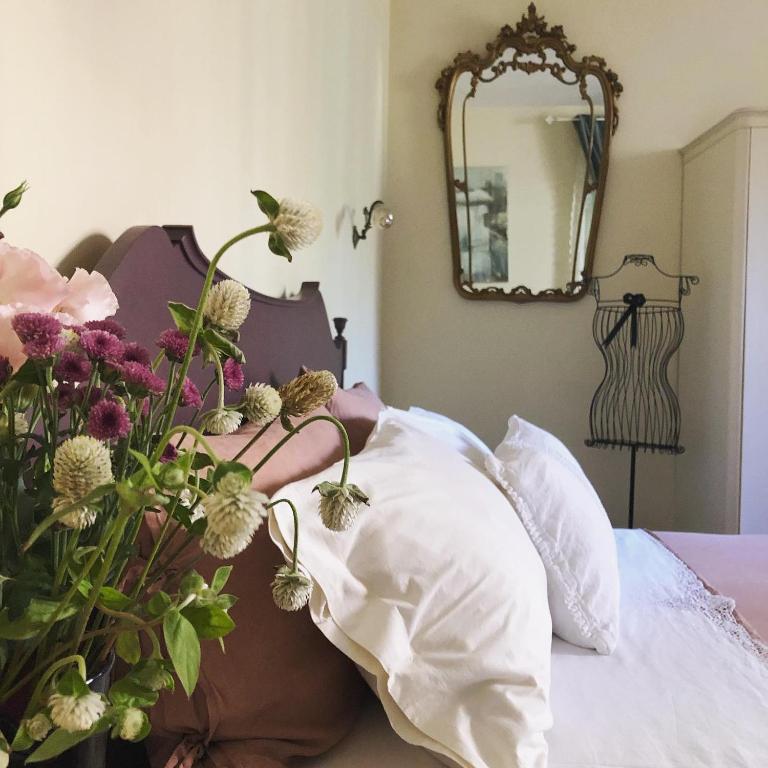 a vase of flowers sitting on top of a bed at Tiramisù in Tivoli