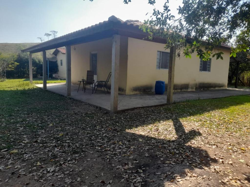 une petite maison blanche avec un toit dans l'établissement Chácara Sagrada Família, à Cachoeira Paulista