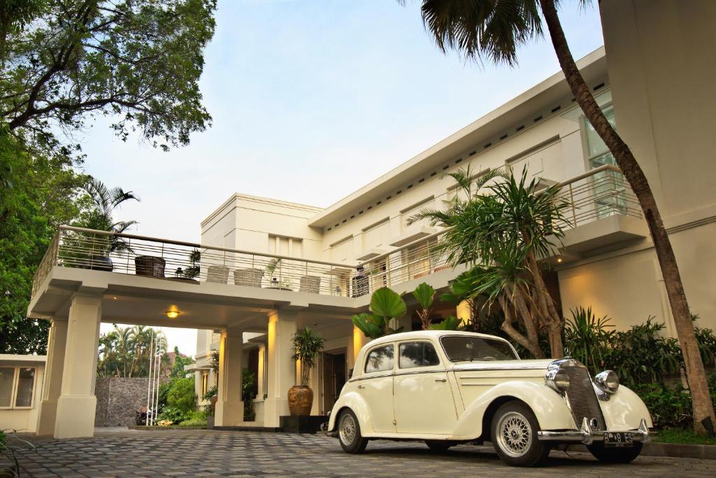 an old white car parked in front of a building at The Shalimar Boutique Hotel in Malang