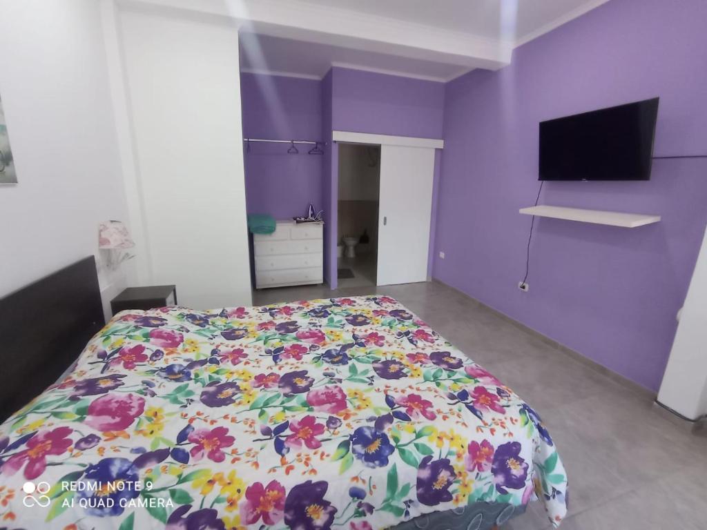 a bedroom with a bed with a floral bedspread at Josefina l in Goya