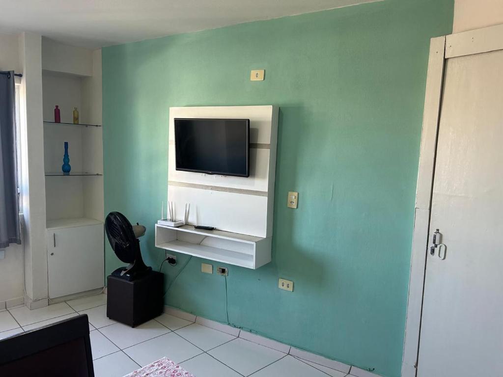 a room with a tv on a blue wall at Recife - Boa Vista in Recife
