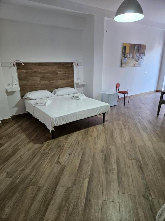 a bedroom with a bed and a wooden floor at Onda Blu in Agropoli
