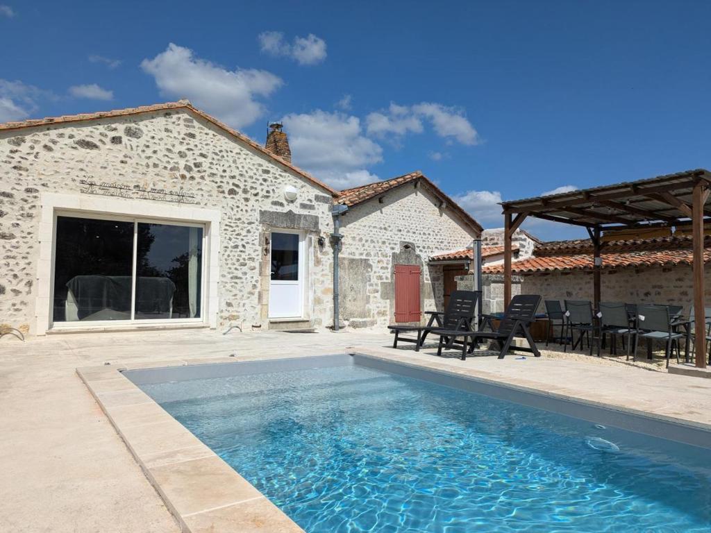 a house with a swimming pool in front of a house at Maison Familiale avec Piscine Privée et Grand Jardin - FR-1-653-266 in Magnac-Lavalette