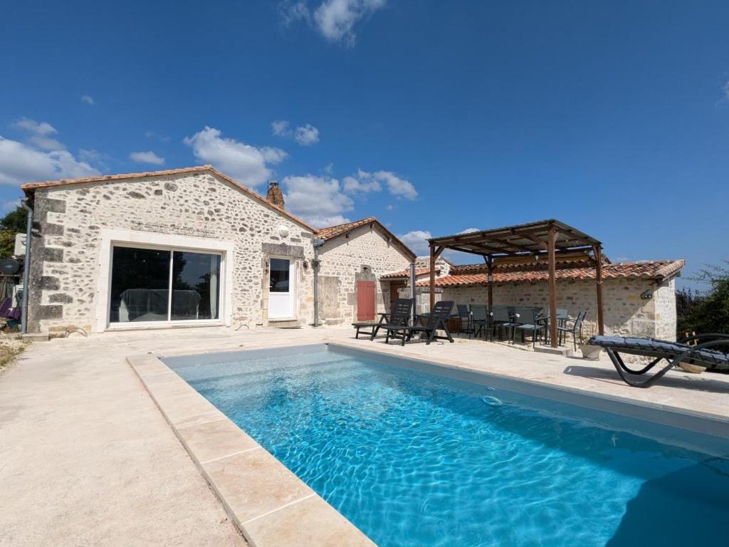 a villa with a swimming pool in front of a house at Maison familiale avec piscine privée et jardin pour 11 pers - FR-1-653-265 in Magnac-Lavalette