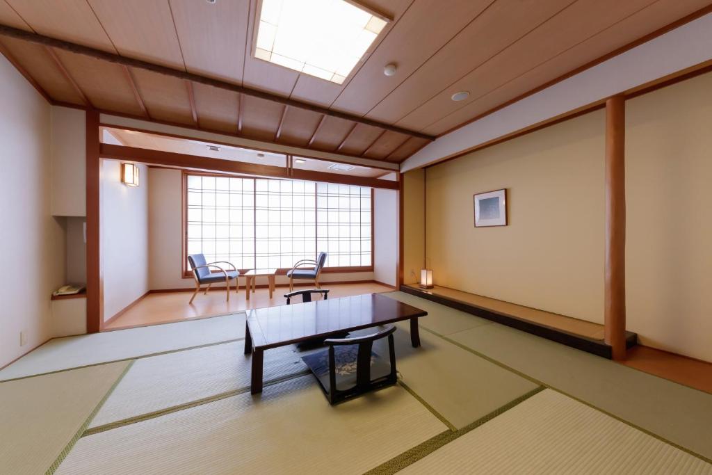 une pièce avec une table, des chaises et une fenêtre dans l'établissement Hotel New Momiji, à Nasushiobara