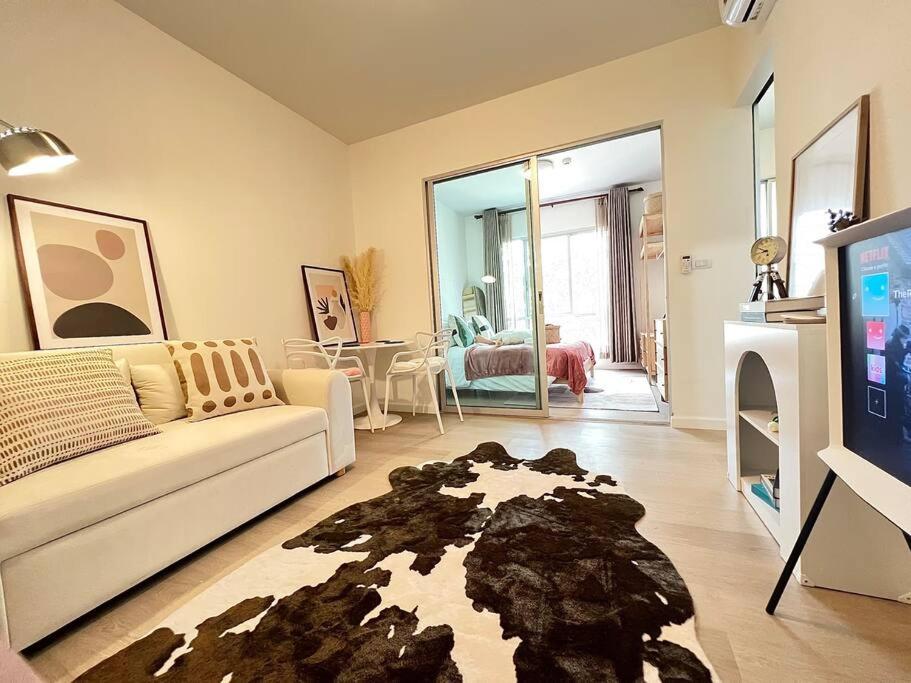 a living room with a white couch and a tv at Self Check in 10min to BKKairport Train2Town Near Mall Local Market WIFI in Bangkok