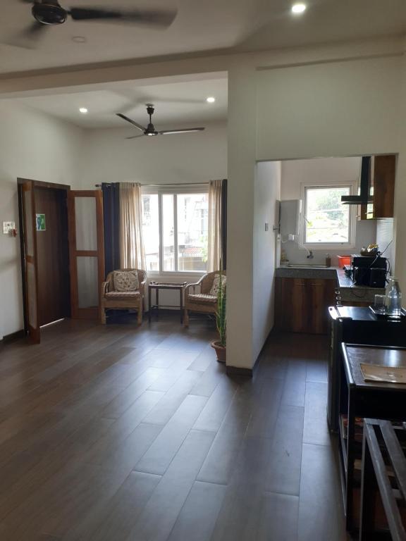 a living room with a kitchen and a dining room at Gruham Homestay in Jorhāt