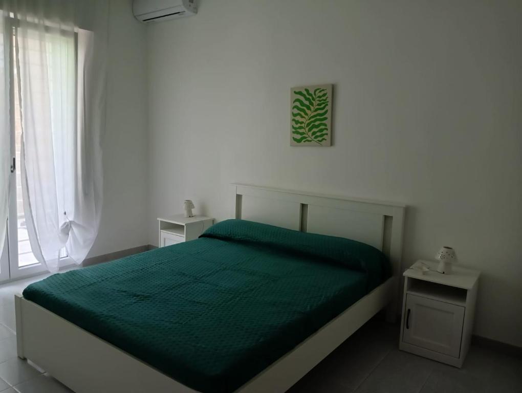 a bedroom with a green bed and a window at Green54verde in Santo Spirito