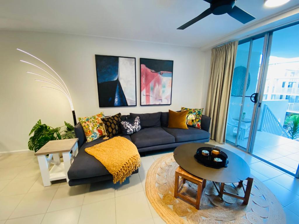 a living room with a couch and a table at Strand to Stadium - Perfect central location in Townsville City in Townsville