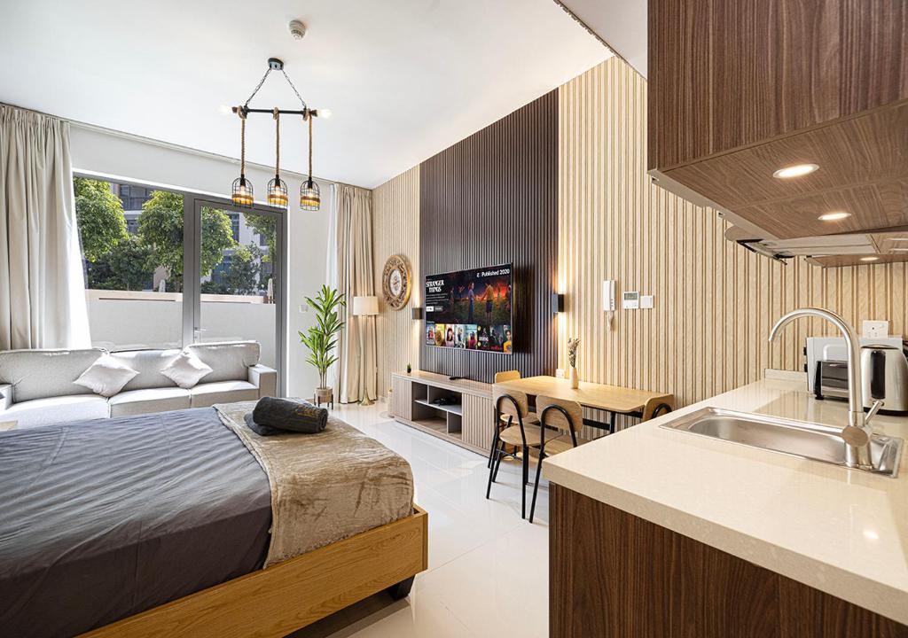 Un dormitorio con una cama y una cocina con fregadero. en Apartment With Private Garden - Luxe Gold, en Sharjah